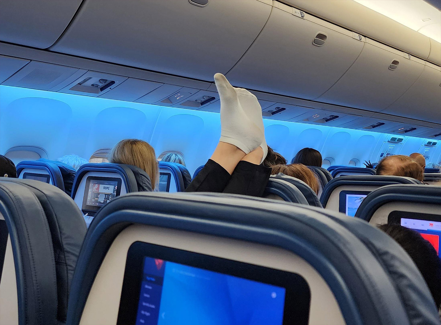 Passenger putting their smelly feet on the headrest during a flight.