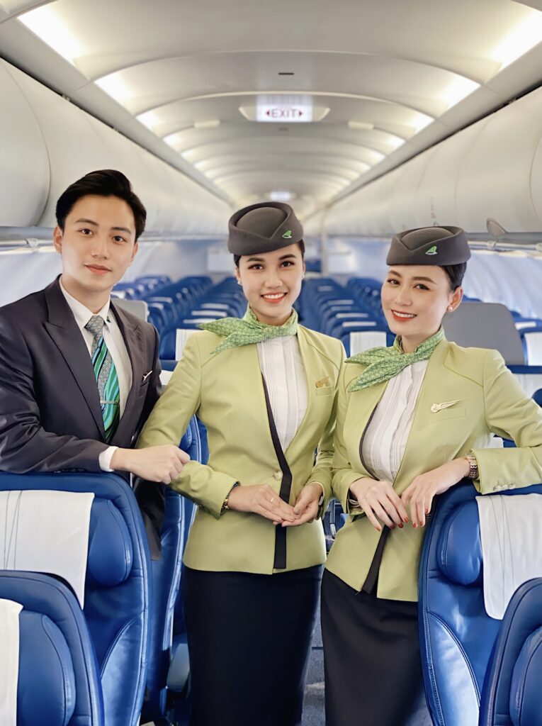 Bamboo Airways females and male Flight Attendants standing in the cabin.