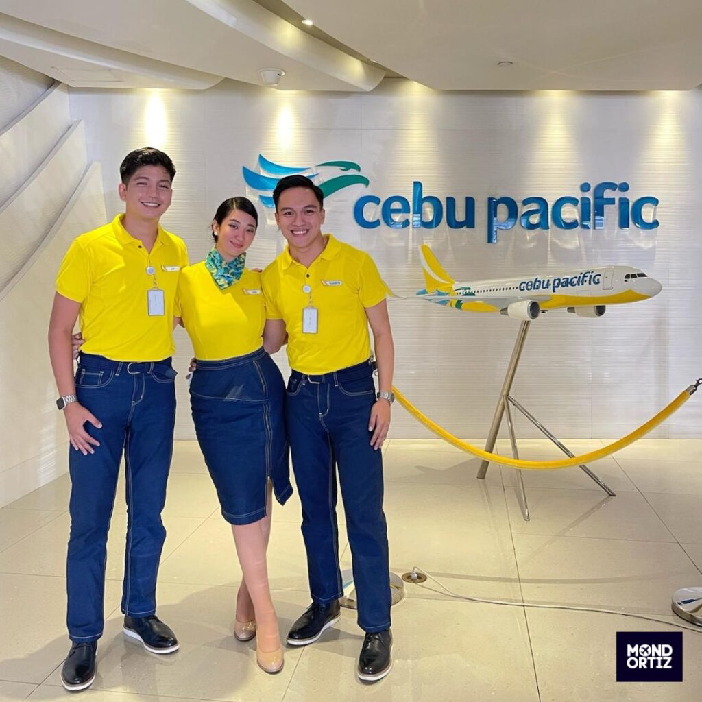 Cebu Pacific Cabin Crew standing next to Cebu Plane model.