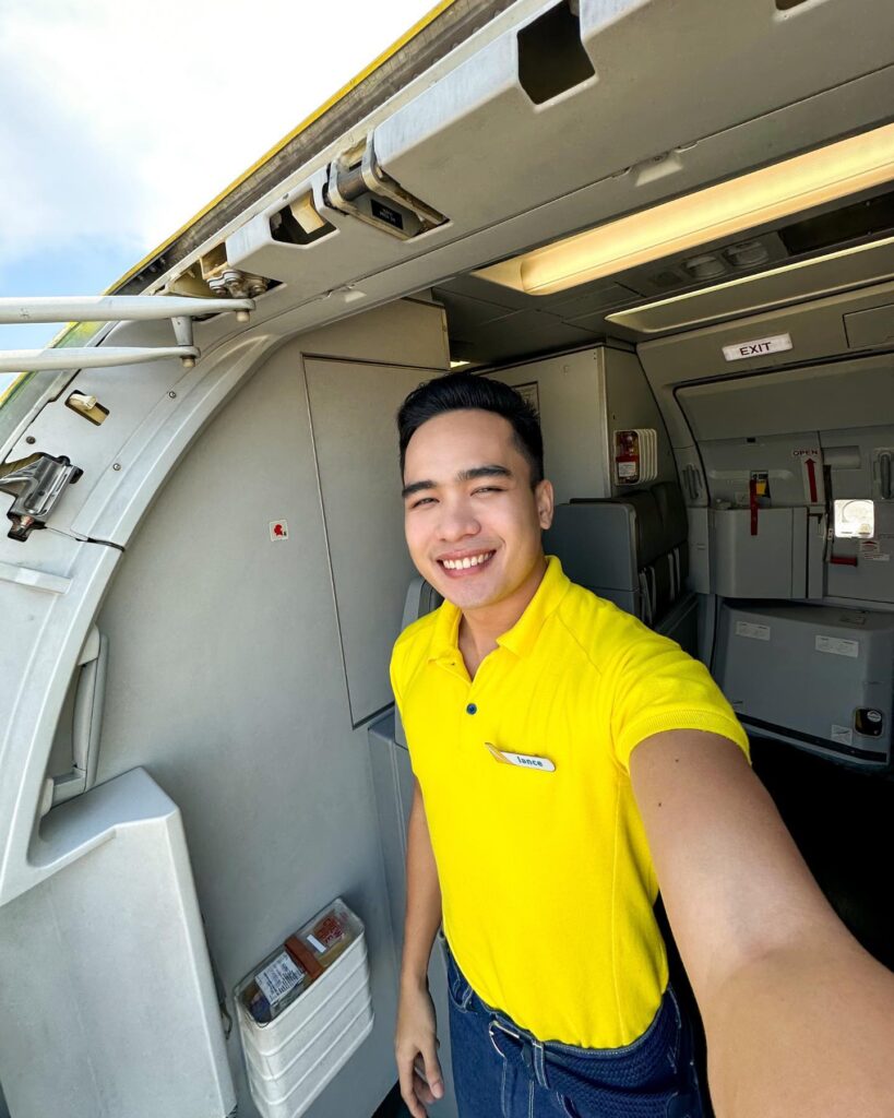 Cebu Pacific male Flight Attendant standing at the door.