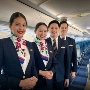 Philippine Airlines male and female cabin crew members in the cabin.