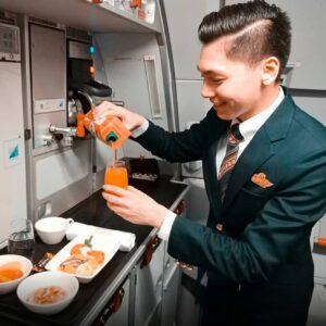 Philippine Airlines male flight attendant preparing meals.
