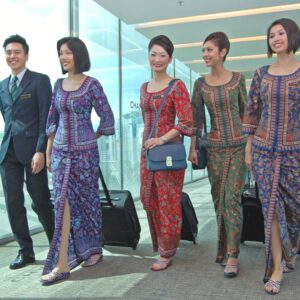 Singapore Airlines cabin crew members walking through aero bridge.