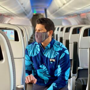 Hawaiian Airlines male Flight Attendant in the cabin.