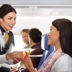 Lufthansa female Flight Attendant serving food.